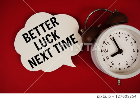 Better Luck Next Time text on speech bubble with alarm clock on red background 127605254