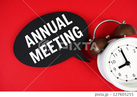 Annual Meeting text on speech bubble with alarm clock on red background 127605255