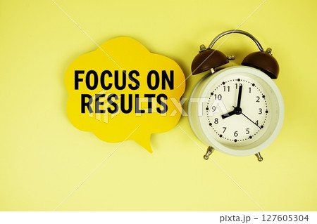 Focus On Results text on speech bubble with alarm clock on yellow background 127605304