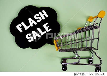 Flash Sale text with speech bubble and trolley shopping cart on green background 127605321