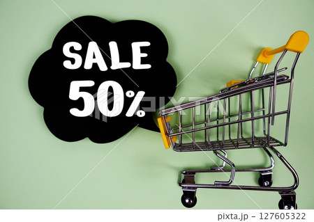 Sale 50% text with speech bubble and trolley shopping cart on green background Sale 50% text with speech bubble and trolley shopping cart on green background 127605322
