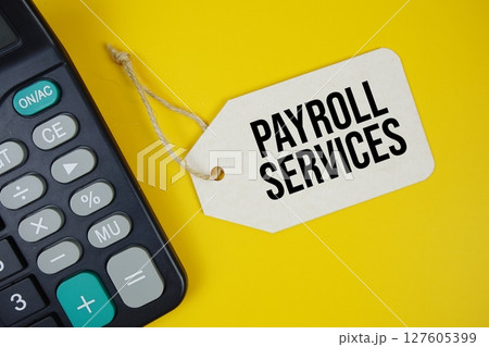 Payroll Services text on price tag with alarm clock and calculator on yellow background Payroll Services text on price tag with alarm clock and calculator on yellow background 127605399