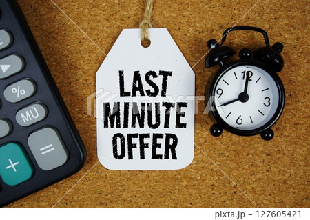 Last Minute Offer text on price tag with alarm clock and calculator on cork board background 127605421