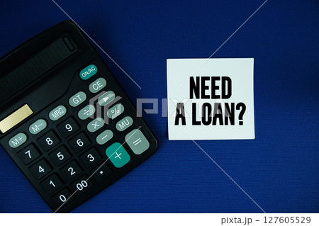 Need A Loan? text on speech bubble with calculator top view on blue background 127605529