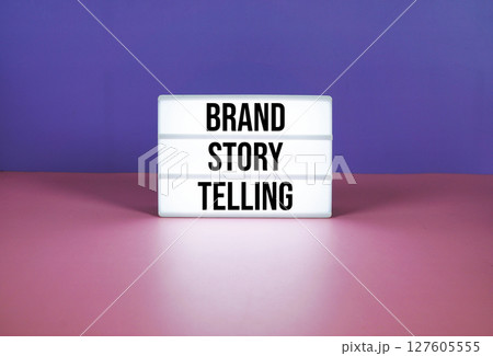 Brand Story Telling text on LED lightbox on purple and pink geometric background Brand Story Telling text on LED lightbox on purple and pink geometric background 127605555