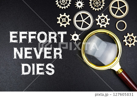 Effort Never Dies text message with magnifying glass on black background 127605831