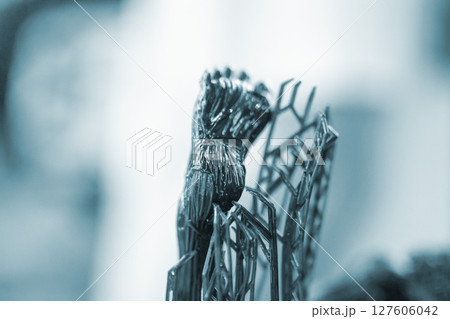 An object printed on a 3D printer from hardened rubber close-up. Model black color created on a 3D printer from hardened rubber under influence of ultraviolet light. SLA 3D printing. Stereolithography 127606042