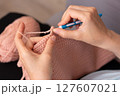 A woman crochets at home 127607021