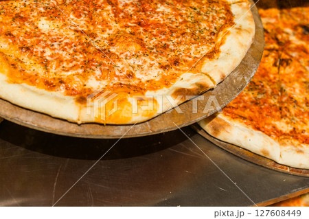 Classic cheese pizza fresh from the oven with golden crust and melted toppings. Italian fast food, casual dining and comfort eating for everyday indulgence. Classic cheese pizza fresh from the oven with golden crust and melted toppings. Italian fast food, casual dining and comfort eating for everyday indulgence. 127608449
