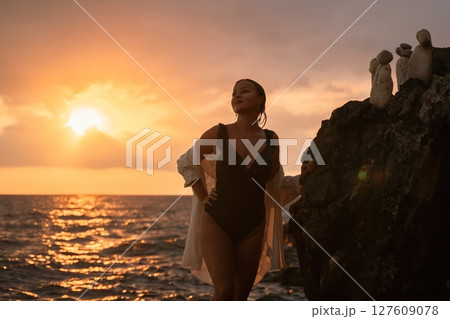 Woman Sunset Beach Rocky Coastline - Enjoying a scenic sunset by the ocean, a woman stands on a rocky coastline. Woman Sunset Beach Rocky Coastline - Enjoying a scenic sunset by the ocean, a woman stands on a rocky coastline. 127609078