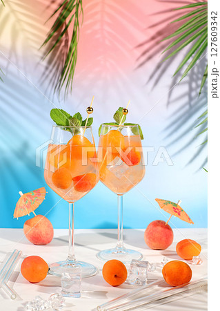 Modern still life with fruits. Royal lemonade cocktail with peach, apricot, mojito with tequila, gin, rum, ice and fresh mint, bar and party concept, restaurant and cafe advertising card Modern still life with fruits. Royal lemonade cocktail with peach, apricot, mojito with tequila, gin, rum, ice and fresh mint, bar and party concept, restaurant and cafe advertising card 127609342