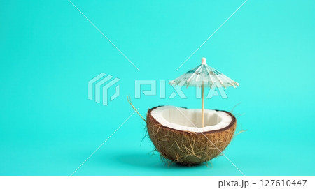 Half coconut shell on turquoise background 127610447