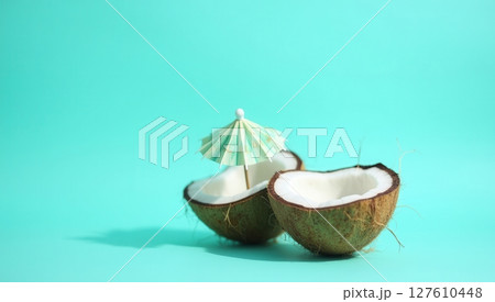 Half coconut shell on turquoise background 127610448