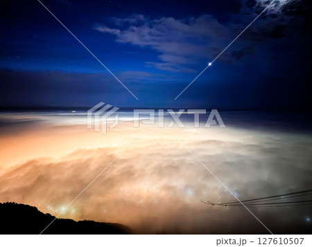 夜景の光に照らされた雲海 127610507