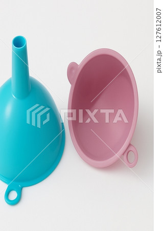Colorful plastic kitchen funnels  pink and blue plastic funnels on white background 127612007