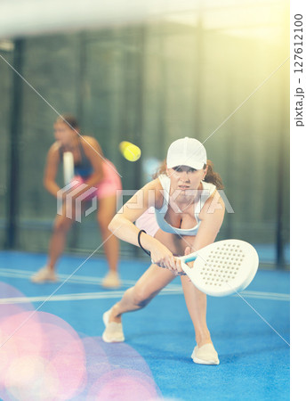 Young and adult women playing doubles tennis Young and adult women playing doubles tennis 127612100