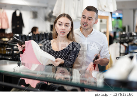 Couple young woman and young man choosing blouse Couple young woman and young man choosing blouse 127612160
