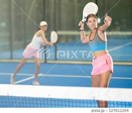 Young and adult women playing doubles tennis Young and adult women playing doubles tennis 127612204