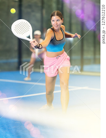 Sportive woman and other members engaged in Padel Tennis in indoor court of tennis club 127612210
