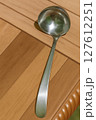 Stainless steel soup ladle on wooden background kitchen utensil close-up photo Stainless steel soup ladle on wooden background kitchen utensil close-up photo 127612251
