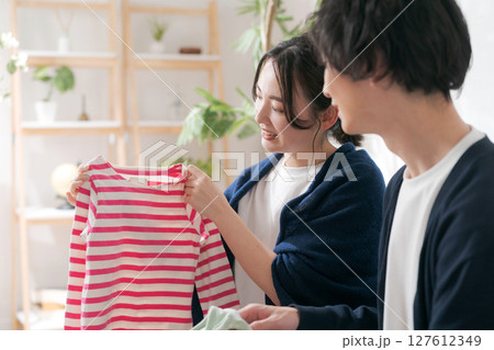 洋服を整理する夫婦 127612349