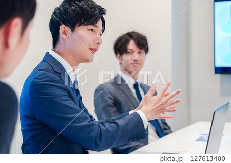 ミーティングで発言をする若い男性ビジネスマン 127613400