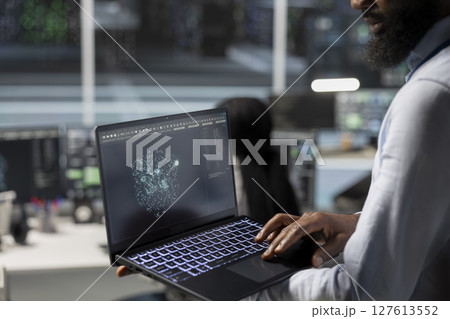 Close up of data center engineer using laptop to implement AI virtualization frameworks, improving resource allocation. Server hub worker does artificial intelligence predictive analysis on notebook Close up of data center engineer using laptop to implement AI virtualization frameworks, improving resource allocation. Server hub worker does artificial intelligence predictive analysis on notebook 127613552