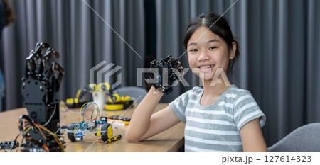 Girl teen smile students education stem hand robot model study in classroom. Learning innovation robot electronic for future AI. System skill training. STEM education 127614323
