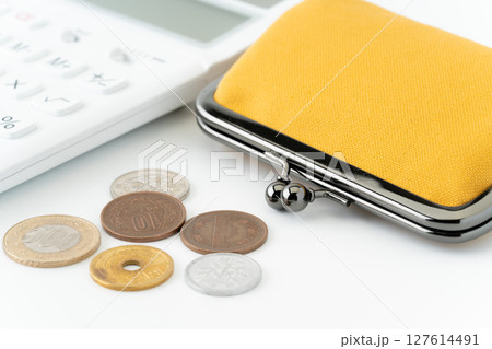白背景に電卓と黄色のがま口財布と硬貨（日本） 127614491