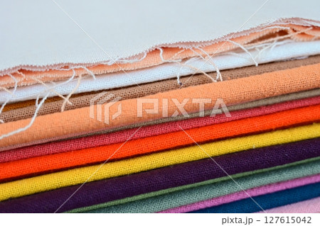 stack of colourful cotton clothes, close up pile of clothing 127615042