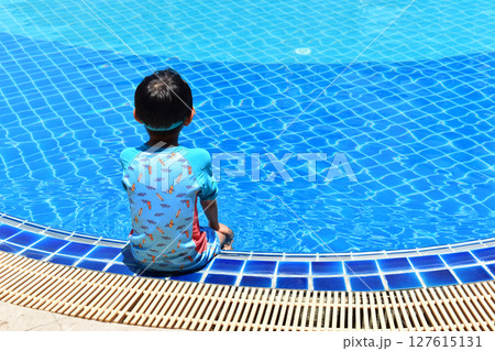 cute boy sit on the swimming pool, happy child 127615131