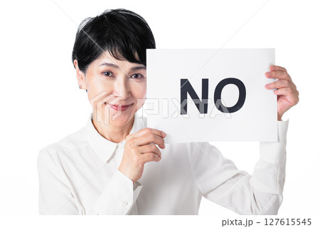 NOと書かれた紙を持ち不適に微笑む中年女性 127615545
