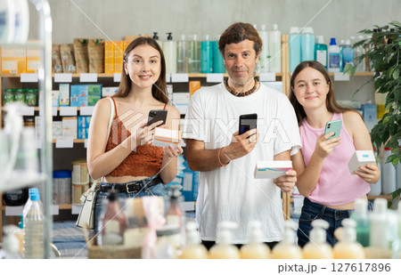 Near display case in pharmacy, family scans barcode on tablet pills package Near display case in pharmacy, family scans barcode on tablet pills package 127617896