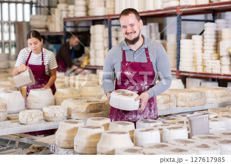 Young man showing poured clay molds 127617985