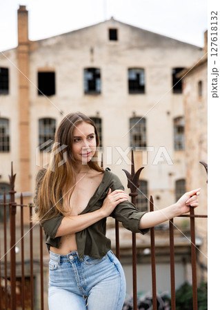 Outdoor fashion - beautiful blonde woman posing near wrought iron fence 127618132