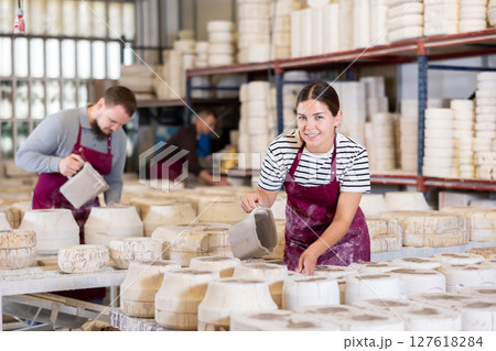 Young woman pouring clay into mold 127618284