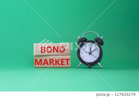 Bond Market symbol. Concept words Bond Market on wooden blocks. Beautiful green background with alarm clock. Business and Bond Market concept. Copy space. Bond Market symbol. Concept words Bond Market on wooden blocks. Beautiful green background with alarm clock. Business and Bond Market concept. Copy space. 127620279