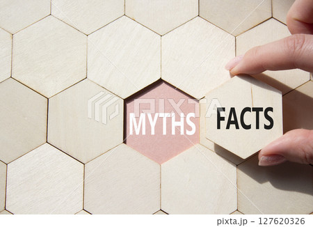 Facts or Myths symbol. Concept word Facts or Myths on wooden comb puzzle. Businessman hand. Beautiful pink background. Business and Facts or Myths concept. Copy space 127620326