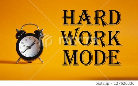 Hard Work Mode symbol. Concept word Hard Work Mode on Beautiful orange background with alarm clock. Business and Hard Work Mode concept. Copy space Hard Work Mode symbol. Concept word Hard Work Mode on Beautiful orange background with alarm clock. Business and Hard Work Mode concept. Copy space 127620336
