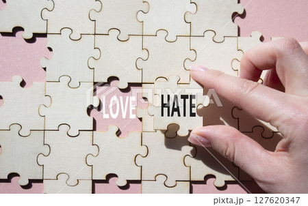 Love vs Hate symbol. Concept word Love vs Hate on wooden puzzle. Businessman hand. Beautiful pink background. Business and Love vs Hate concept. Copy space Love vs Hate symbol. Concept word Love vs Hate on wooden puzzle. Businessman hand. Beautiful pink background. Business and Love vs Hate concept. Copy space 127620347