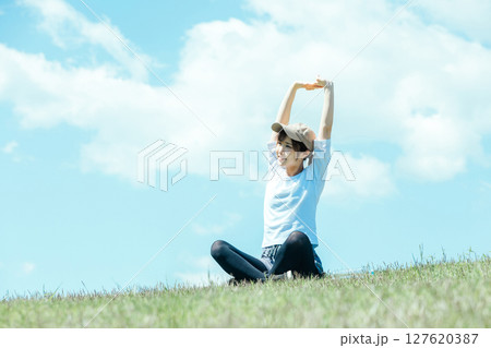 緑の丘でストレッチする女性 緑の丘でストレッチする女性 127620387