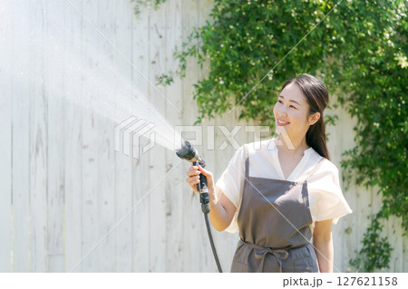 庭に水撒きをする女性 127621158
