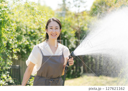 庭に水撒きをする女性 127621162