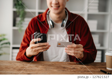 Man hands using smartphone and holding credit card sitting. Online Shopping payments concept. Man hands using smartphone and holding credit card sitting. Online Shopping payments concept. 127621327