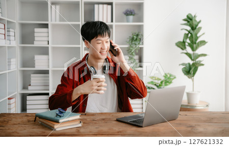 Happy asian business man have the joy of talking on the smartphone, tablet and laptopon the office 127621332