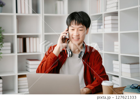 Happy asian business man have the joy of talking on the smartphone, tablet and laptopon the office Happy asian business man have the joy of talking on the smartphone, tablet and laptopon the office 127621333