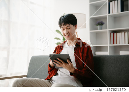 Portrait of a Asian young man sitting at his desk in the office. 127621370