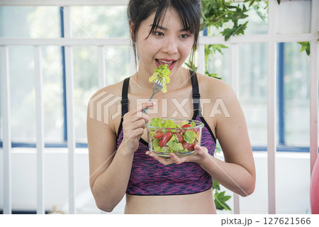 Wellness Asian women dressing organic green salad tomato vegetable dish. Beautiful girl healthcare vegan wellness lifestyle concept. Healthy woman workout holding organic salad bowl healthy lifestyle Wellness Asian women dressing organic green salad tomato vegetable dish. Beautiful girl healthcare vegan wellness lifestyle concept. Healthy woman workout holding organic salad bowl healthy lifestyle 127621566