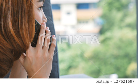 Smiling face asian woman holding smartphone with E-commerce Shopping online website Reading Online Article, Blog, vlog. Young Woman hands holding phone technology lifestyle. Woman using smart phone. 127621697