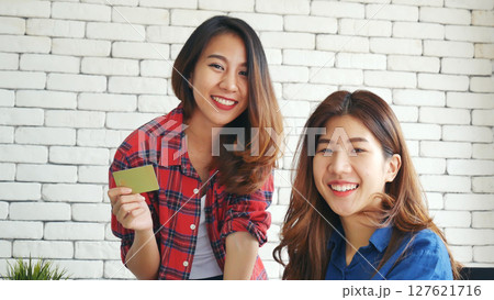 Two friends shopping using credit card online shopping on website laptop e-commerce website with smiling face, happiness. Happy asian women using laptop shopping online buy, payment newnormal concept 127621716